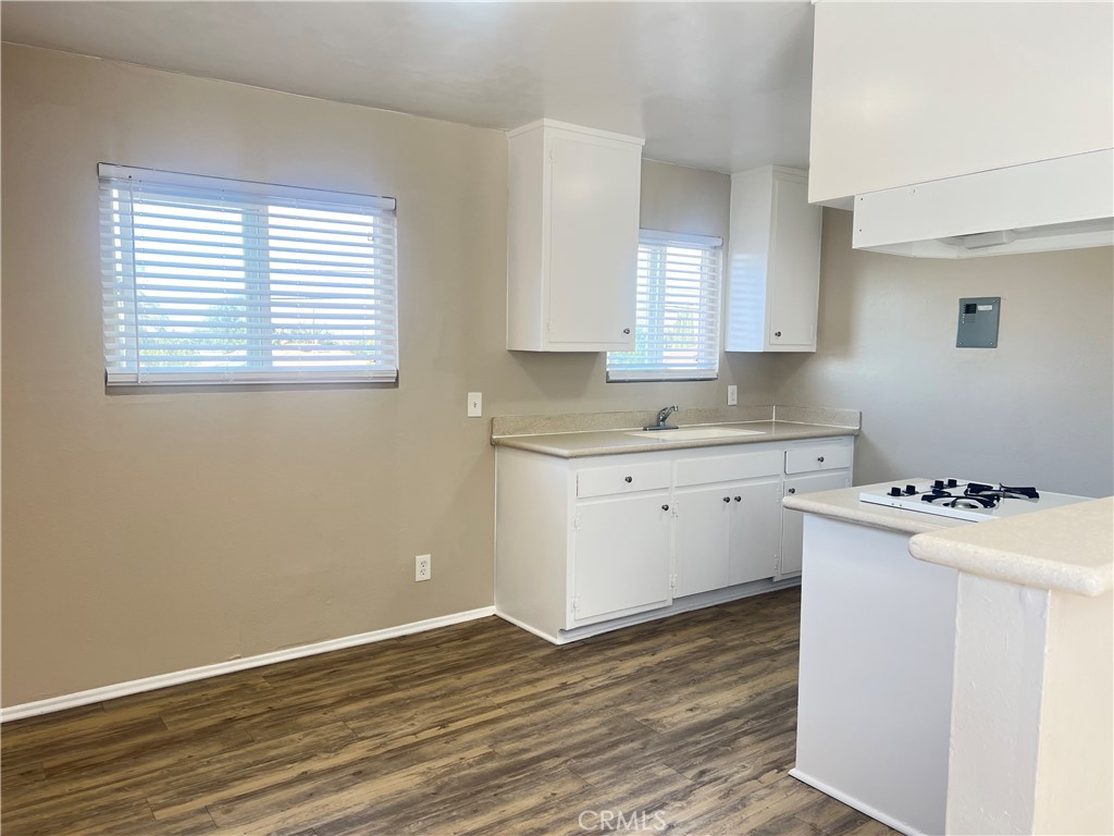 4920 Maine Avenue, Unit M Baldwin Park, CA 91706 - Photo 4 of 17 a room with a stove a sink wooden floor and cabinets
