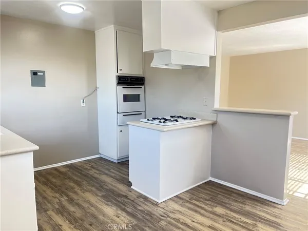 a kitchen with wooden floor and window