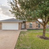 a view of a house with a big yard and large tree