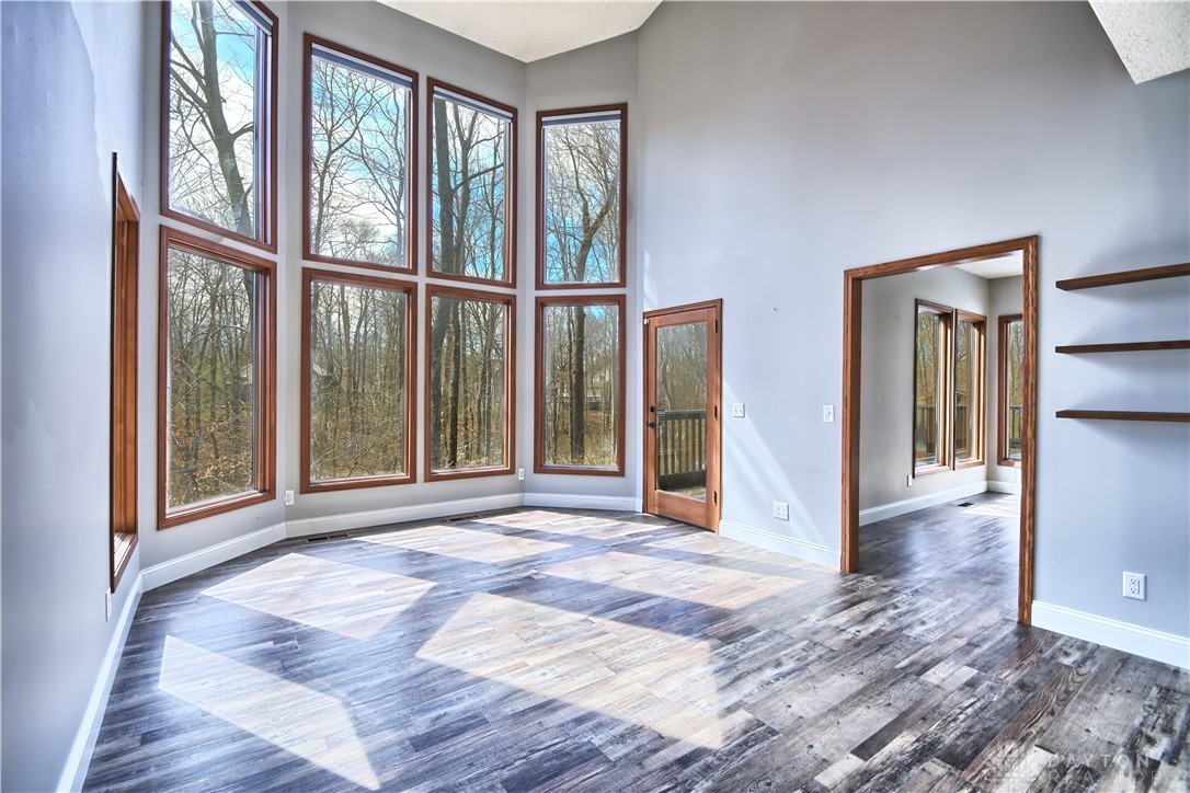 8711 Nicole Lane Springboro, OH 45066 - Photo 20 of 87 This airy room features expansive windows, a high ceiling, and modern flooring, creating a bright and inviting space.