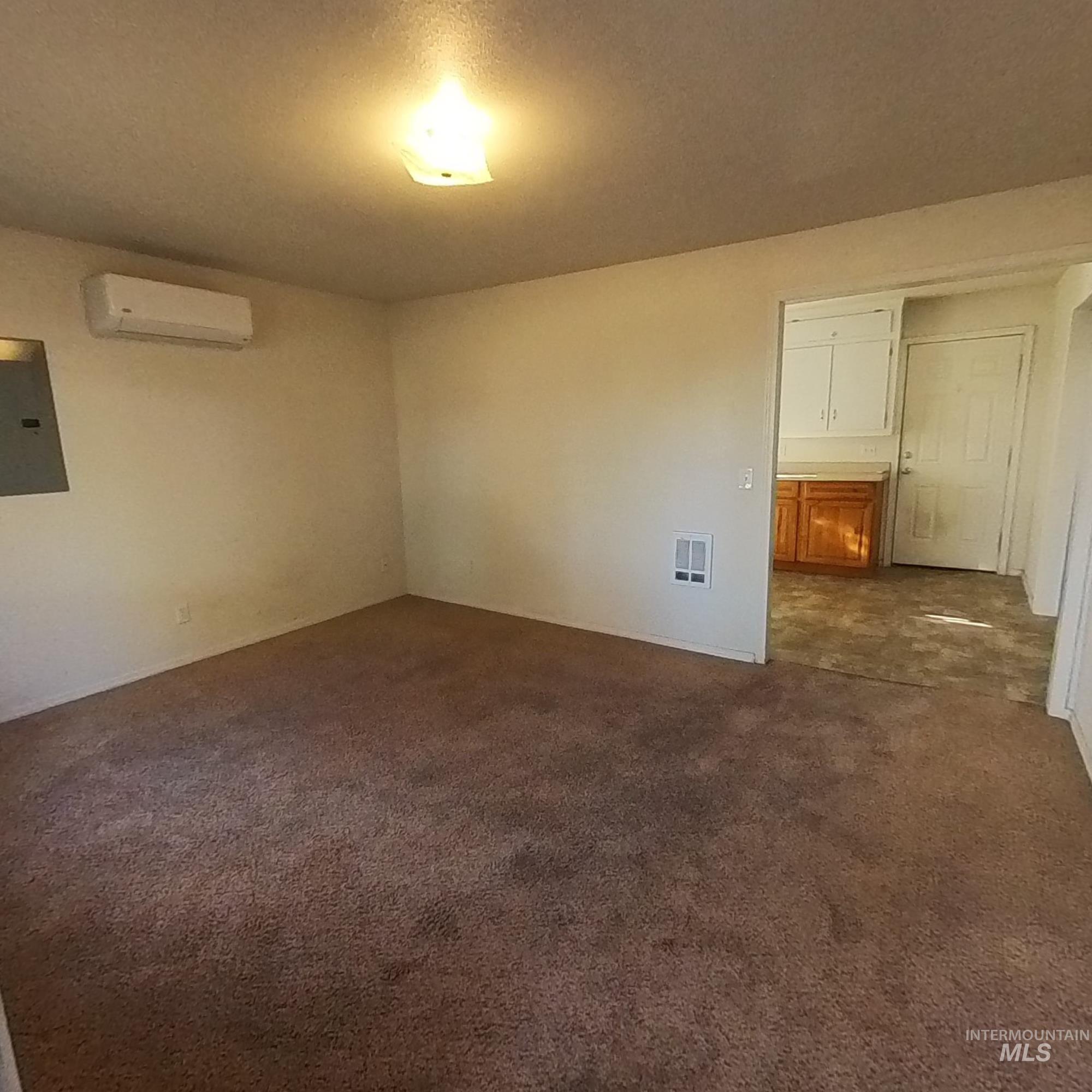 418 13th Street Clarkston, WA 99403 - Photo 26 of 26 Spare room featuring dark carpet, electric panel, and an AC wall unit