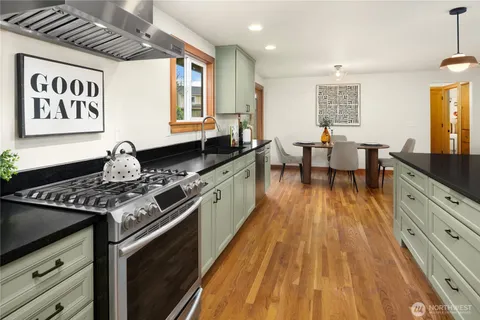 a kitchen with stainless steel appliances granite countertop a stove and a wooden cabinets