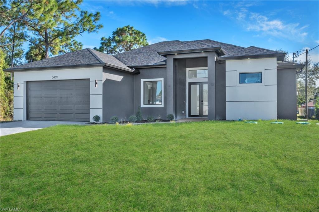 Prairie-style home featuring stucco siding, a front lawn, and a garage