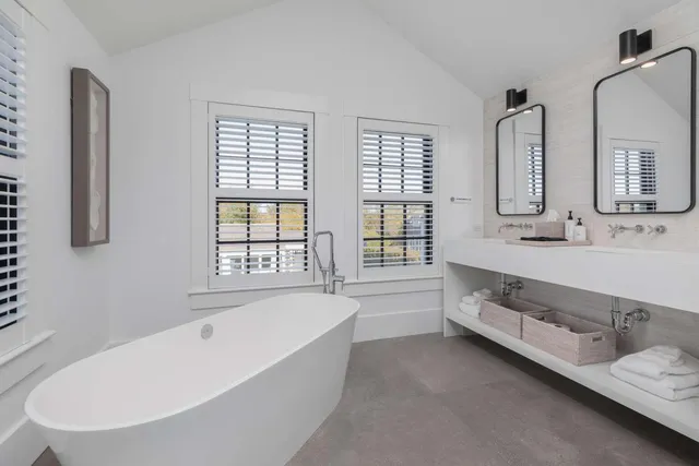 a bathroom with a granite countertop tub sink and mirror