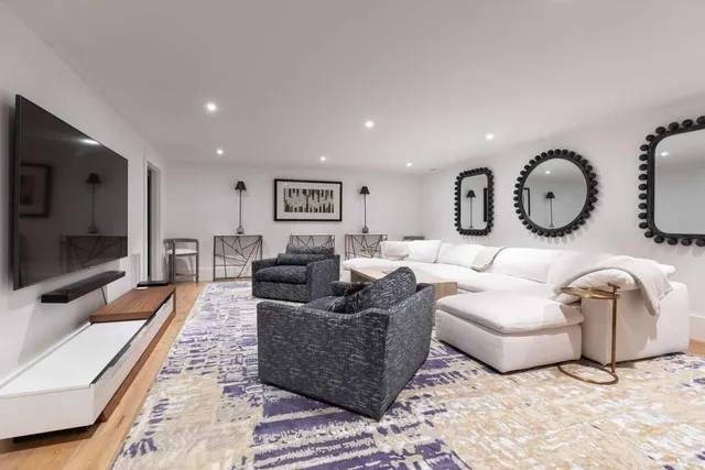 a living room with furniture a flat screen tv and a large window