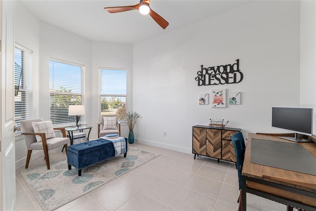 8809 Southwest 61st Loop Ocala, FL 34481 - Photo 20 of 41 a living room with furniture a desk and chair with a bookshelf