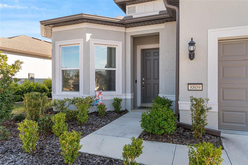 8809 Southwest 61st Loop Ocala, FL 34481 - Photo 3 of 41 front view of a house with potted plants