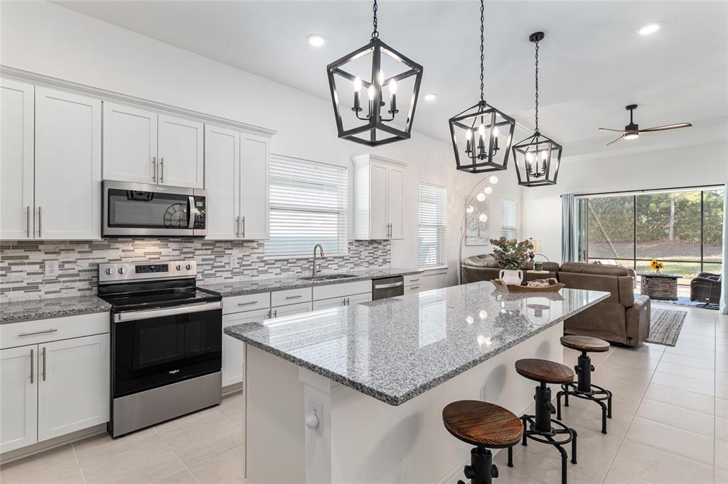 8809 Southwest 61st Loop Ocala, FL 34481 - Photo 4 of 41 a kitchen with living room and chandelier