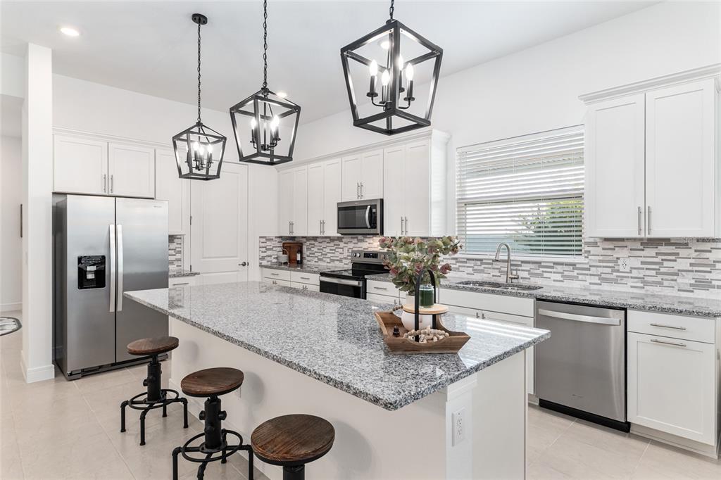8809 Southwest 61st Loop Ocala, FL 34481 - Photo 7 of 41 a kitchen with stainless steel appliances granite countertop a sink a stove and refrigerator