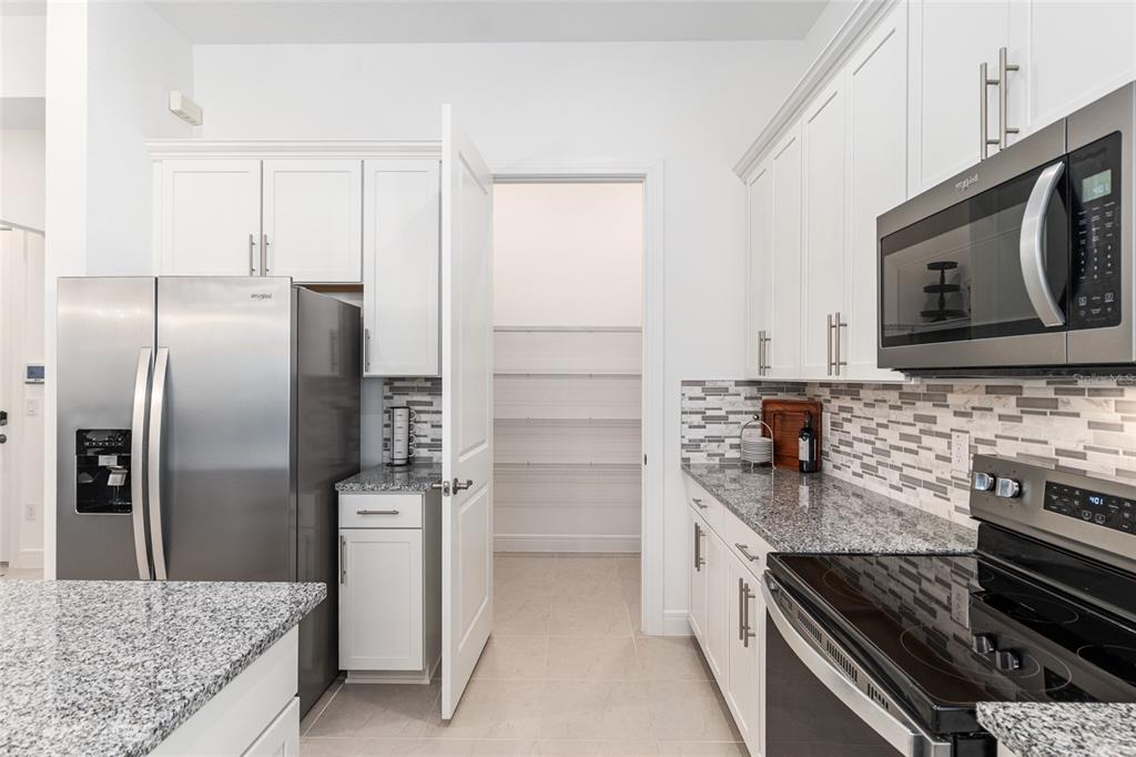 8809 Southwest 61st Loop Ocala, FL 34481 - Photo 8 of 41 a kitchen with stainless steel appliances granite countertop a refrigerator and a stove