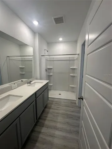 a bathroom with a shower sink and mirror