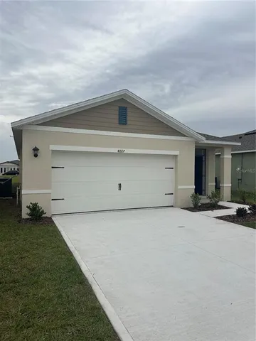 a view of a house with backyard space and garage