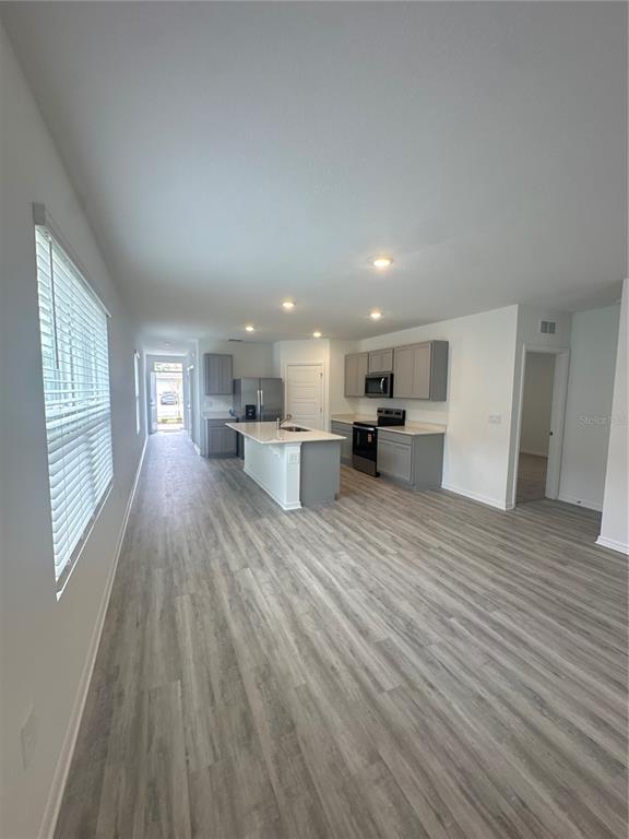4667 Ostero Street Winter Haven, FL 33880 - Photo 7 of 24 a view of kitchen and wooden floor