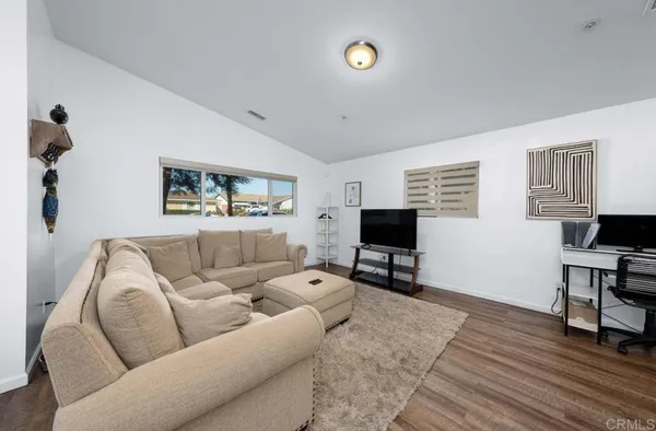 a living room with furniture and a flat screen tv with wooden floor