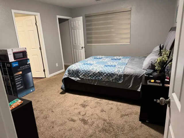 a bed sitting in a bedroom next to a window