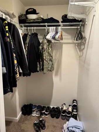 a view of walk in closet with clothes and shoes