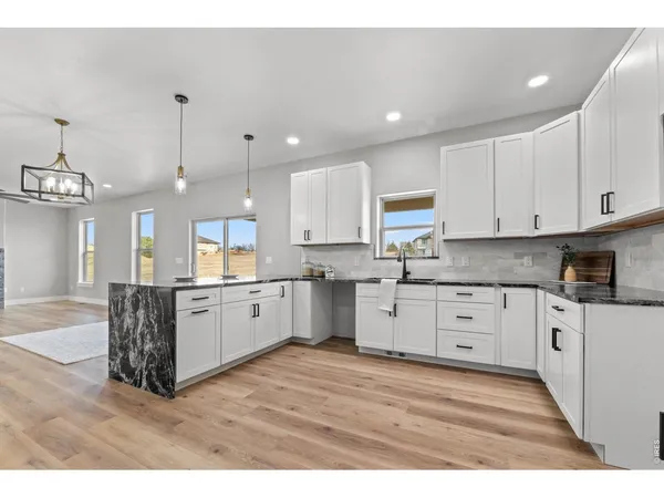 a large kitchen with granite countertop a large counter top and stainless steel appliances