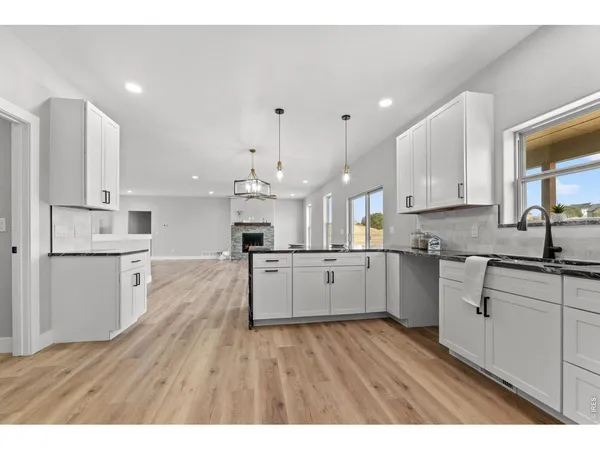 a large kitchen with cabinets wooden floor and stainless steel appliances