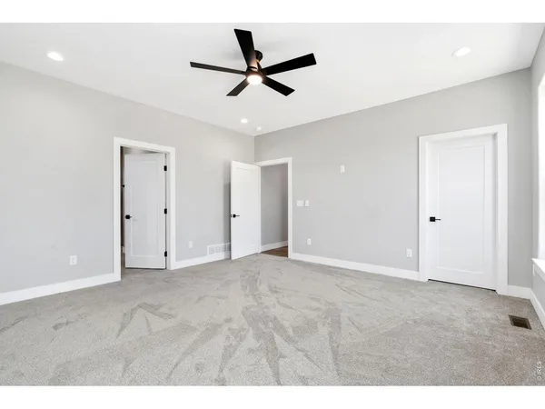 a view of an empty room with a ceiling fan