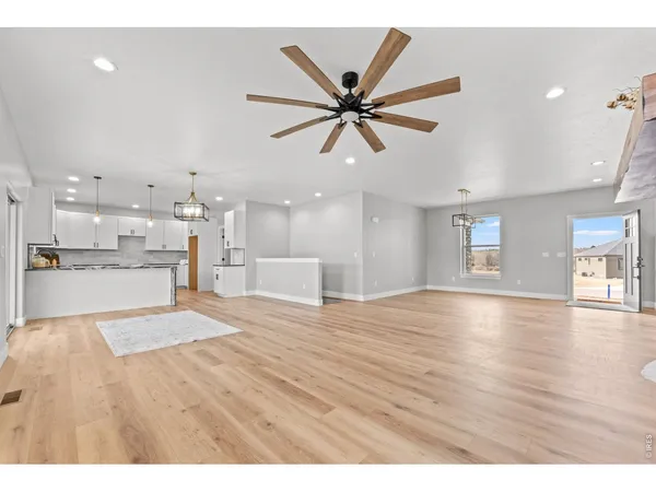 a view of empty room with wooden floor and windows