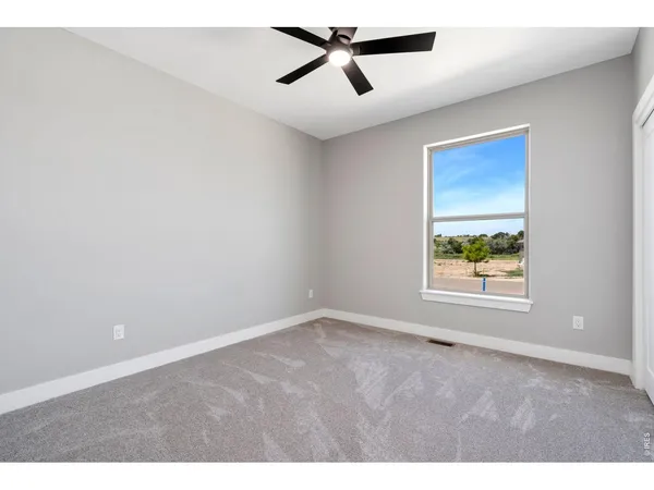 an empty room with a window and a ceiling fan