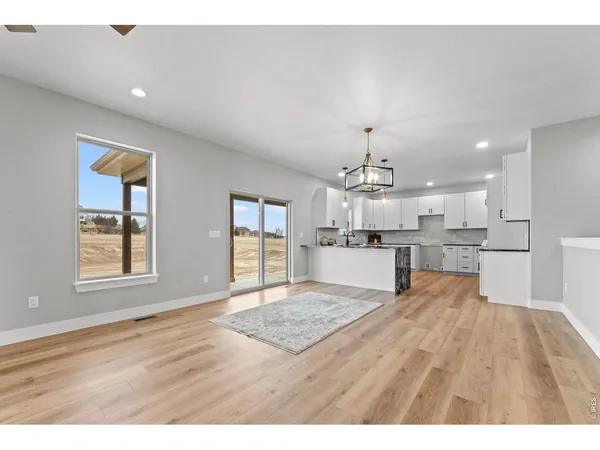 a view of kitchen with granite countertop cabinets and wooden floor