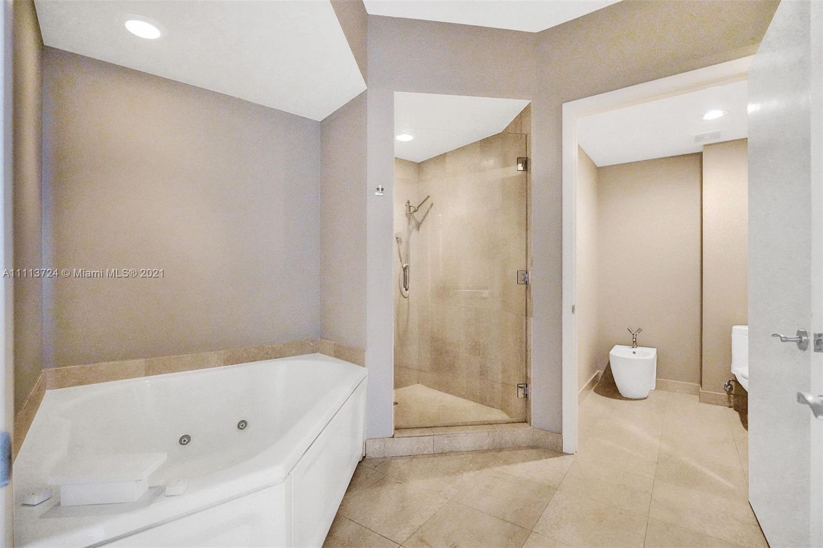 400 Alton Road, Unit 1011 Miami Beach, FL 33139 - Photo 14 of 27 a bathroom with a tub and shower