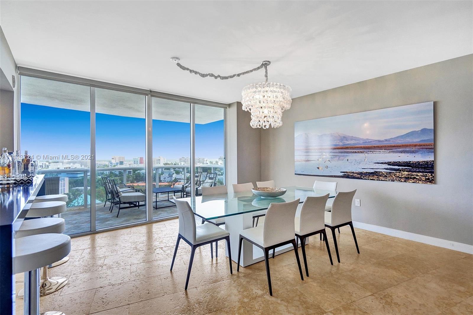 400 Alton Road, Unit 1011 Miami Beach, FL 33139 - Photo 3 of 27 a view of a dining room with furniture wooden floor and chandelier