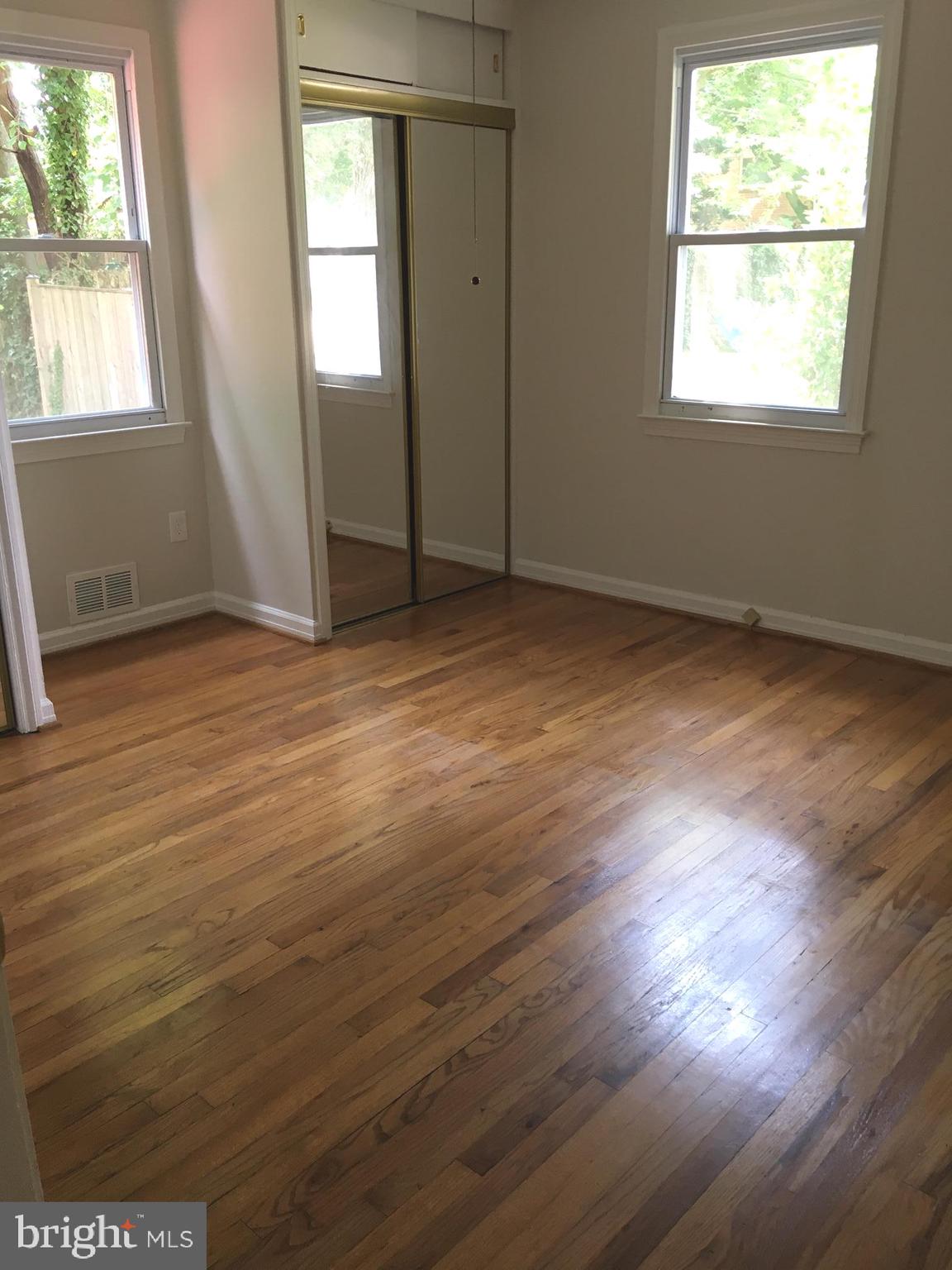 6410 Stoneham Road Bethesda, MD 20817 - Photo 14 of 20 an empty room with wooden floor and windows