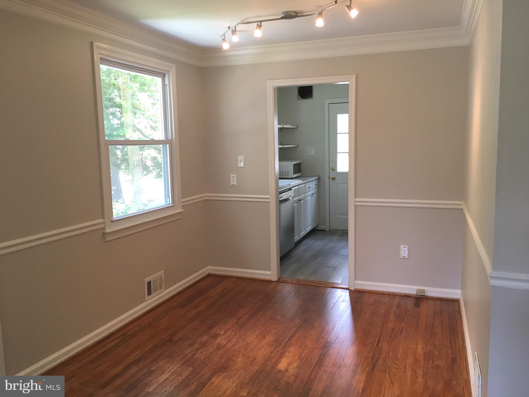 6410 Stoneham Road Bethesda, MD 20817 - Photo 7 of 20 an empty room with wooden floor and windows
