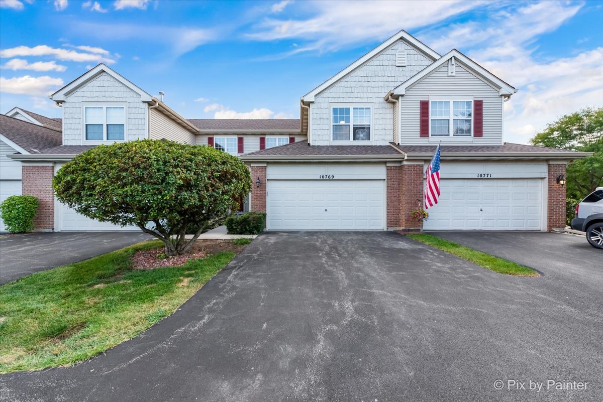a view of front of a house with a yard and garage