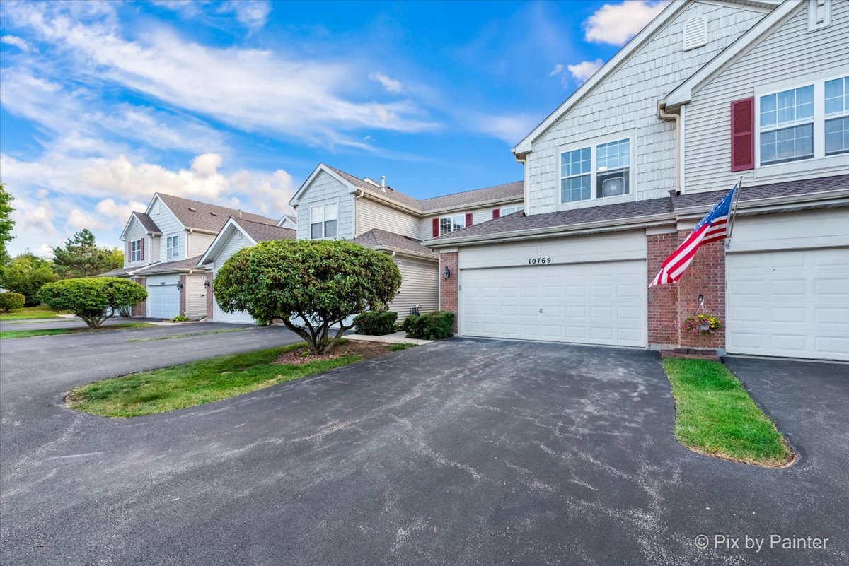 10769 Cape Cod Lane Huntley, IL 60142 - Photo 25 of 25 a front view of a house with a yard and garage