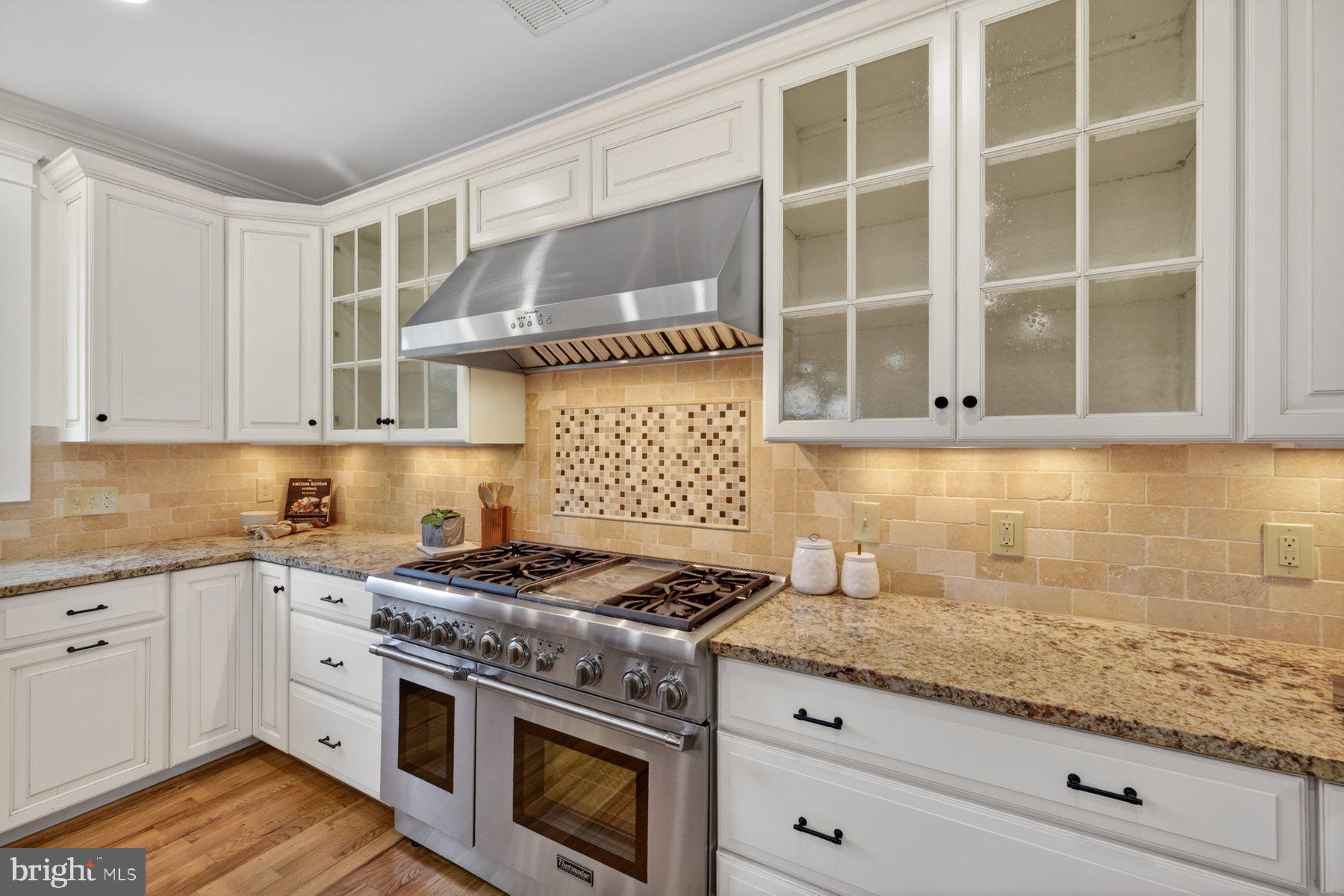 5011 Rugby Avenue Bethesda, MD 20814 - Photo 16 of 65 a kitchen with granite countertop cabinets stainless steel appliances and wooden floor