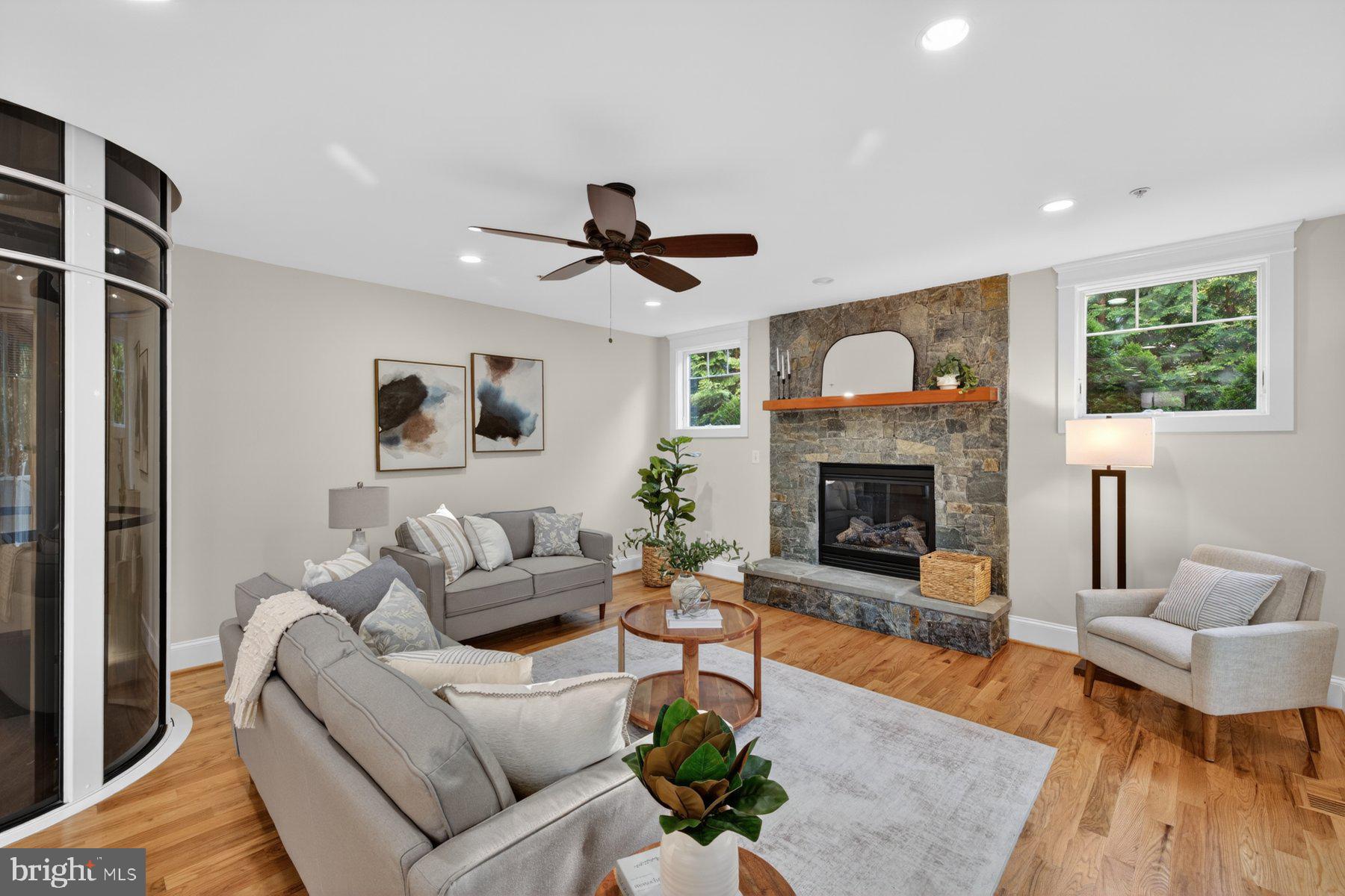 5011 Rugby Avenue Bethesda, MD 20814 - Photo 19 of 65 a living room with furniture a fireplace and a flat screen tv