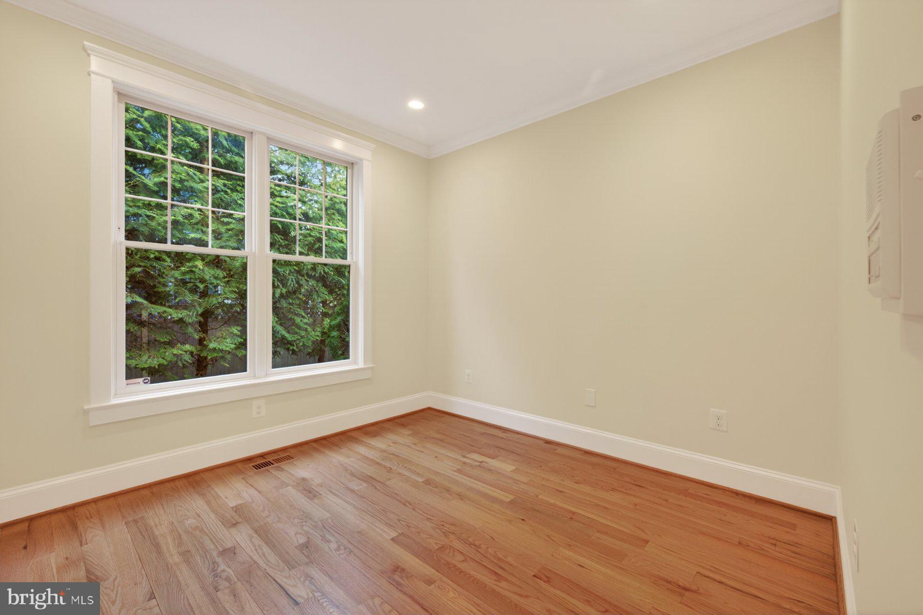 5011 Rugby Avenue Bethesda, MD 20814 - Photo 23 of 65 a view of an empty room with wooden floor and a window