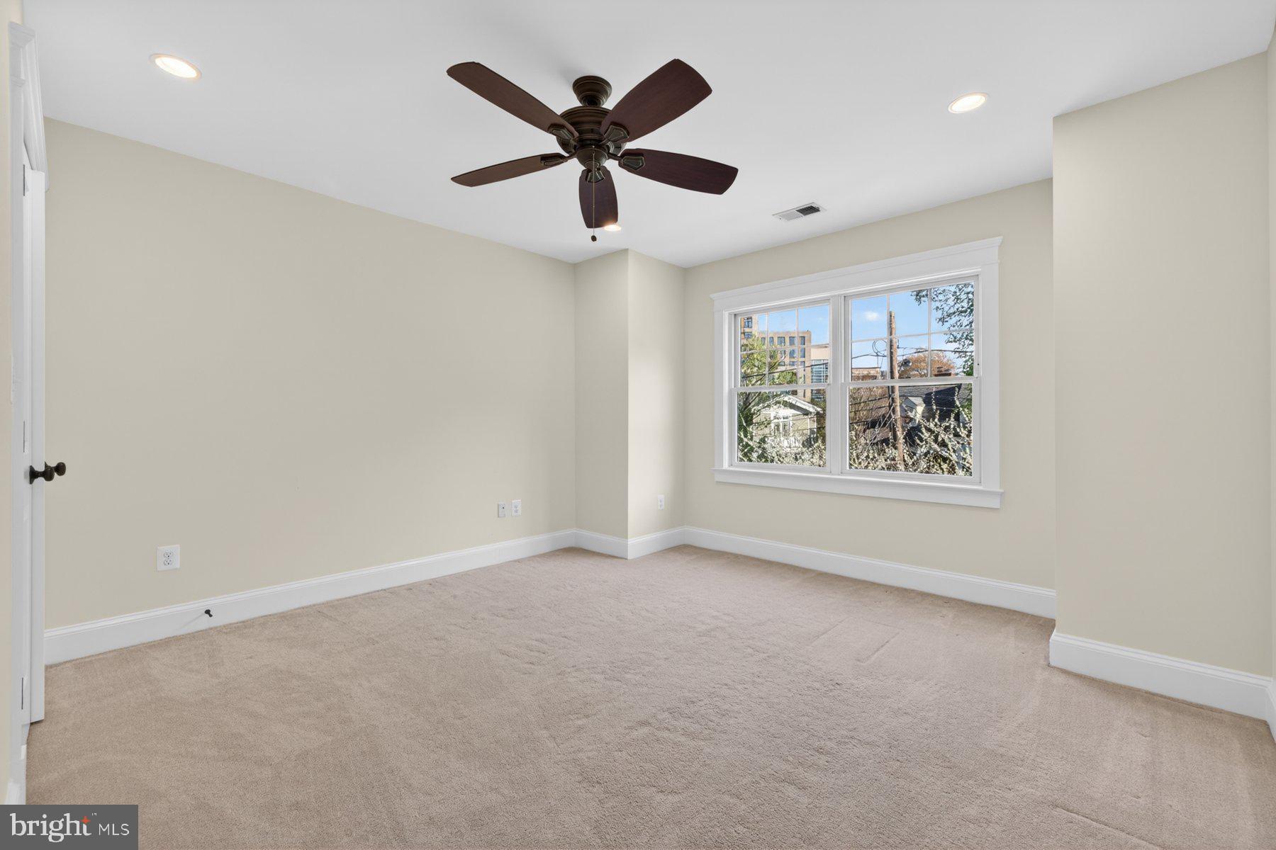 5011 Rugby Avenue Bethesda, MD 20814 - Photo 29 of 65 an empty room with windows and ceiling fan