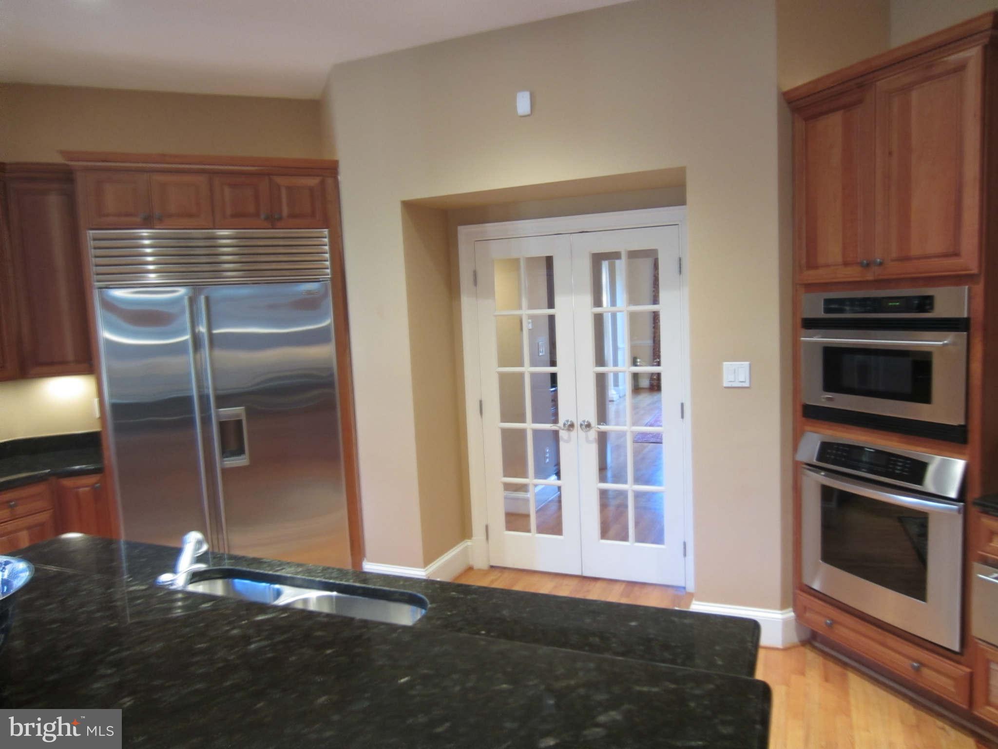 1910 Russell Road Alexandria, VA 22301 - Photo 15 of 25 a view of an empty room with wooden floor and a kitchen