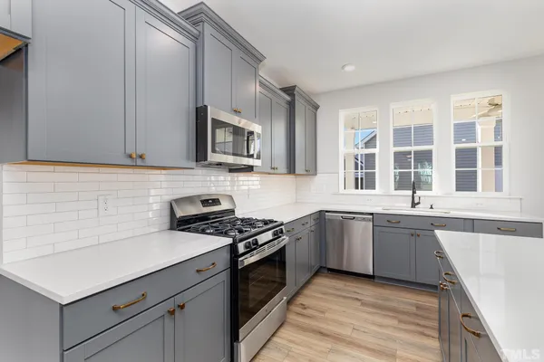 a kitchen with granite countertop cabinets stainless steel appliances and a sink