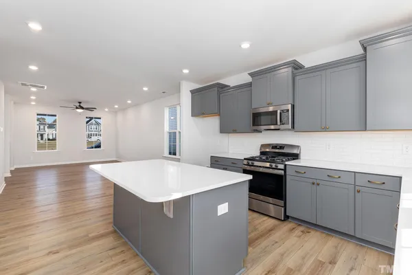 a large kitchen with stainless steel appliances kitchen island a cabinets and wooden floor