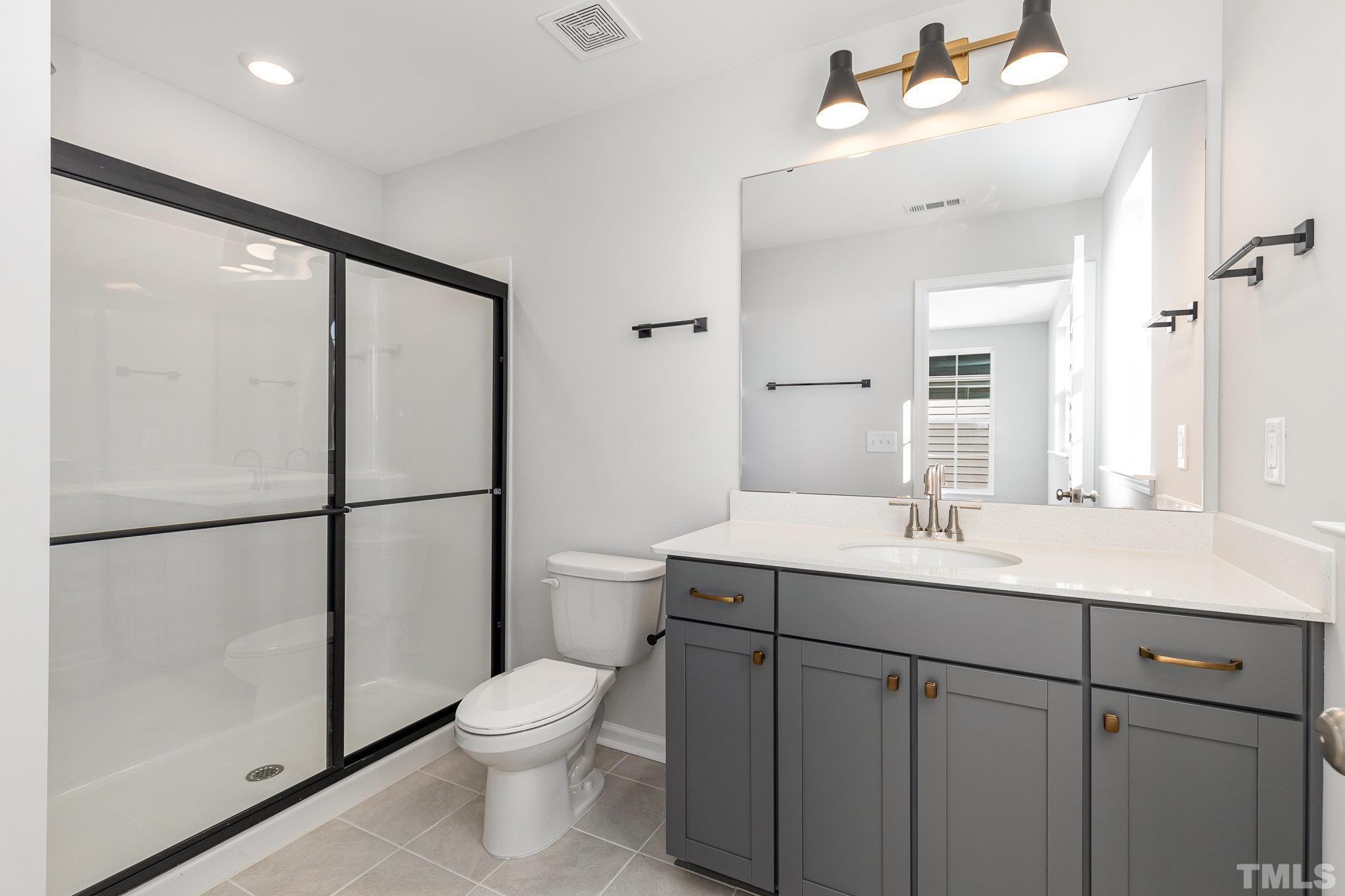 271 Pear Blossom Parkway Clayton, NC 27520 - Photo 15 of 25 a bathroom with a toilet a sink and a mirror