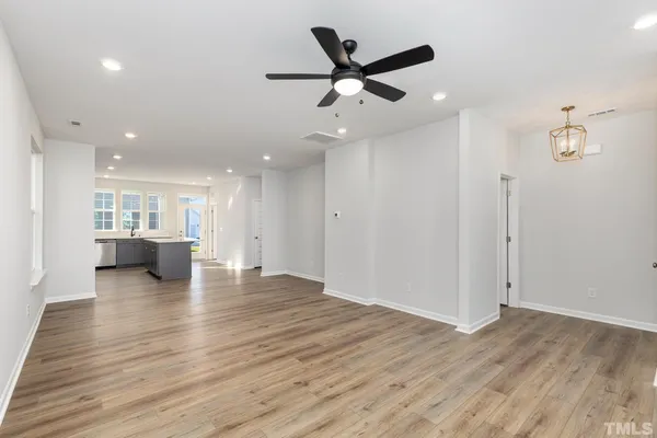 an empty room with wooden floor and a ceiling fan