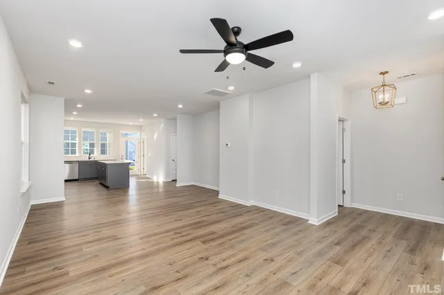 an empty room with wooden floor and a ceiling fan