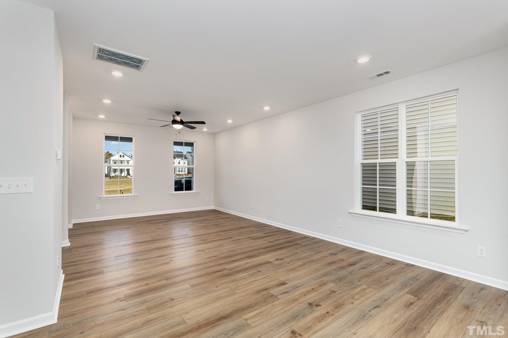 271 Pear Blossom Parkway Clayton, NC 27520 - Photo 7 of 25 a view of an empty room with wooden floor and a window