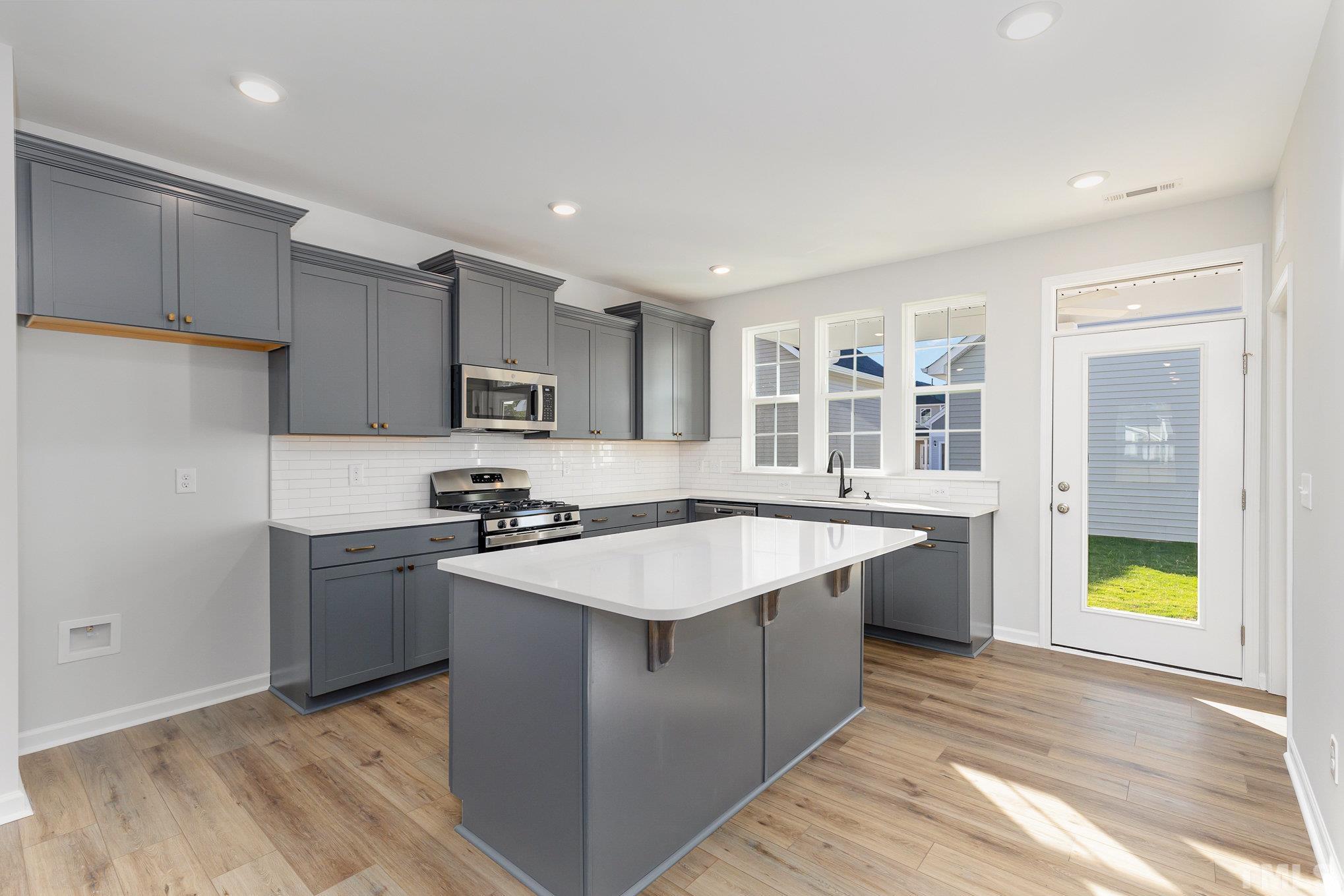 271 Pear Blossom Parkway Clayton, NC 27520 - Photo 8 of 25 a kitchen with stainless steel appliances granite countertop a sink stove and refrigerator