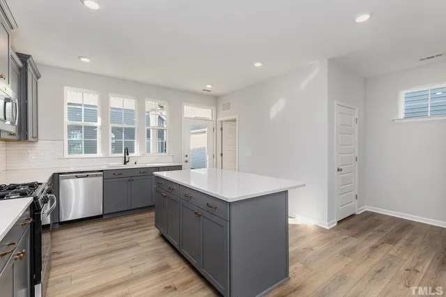 a kitchen with sink stove and wooden floor
