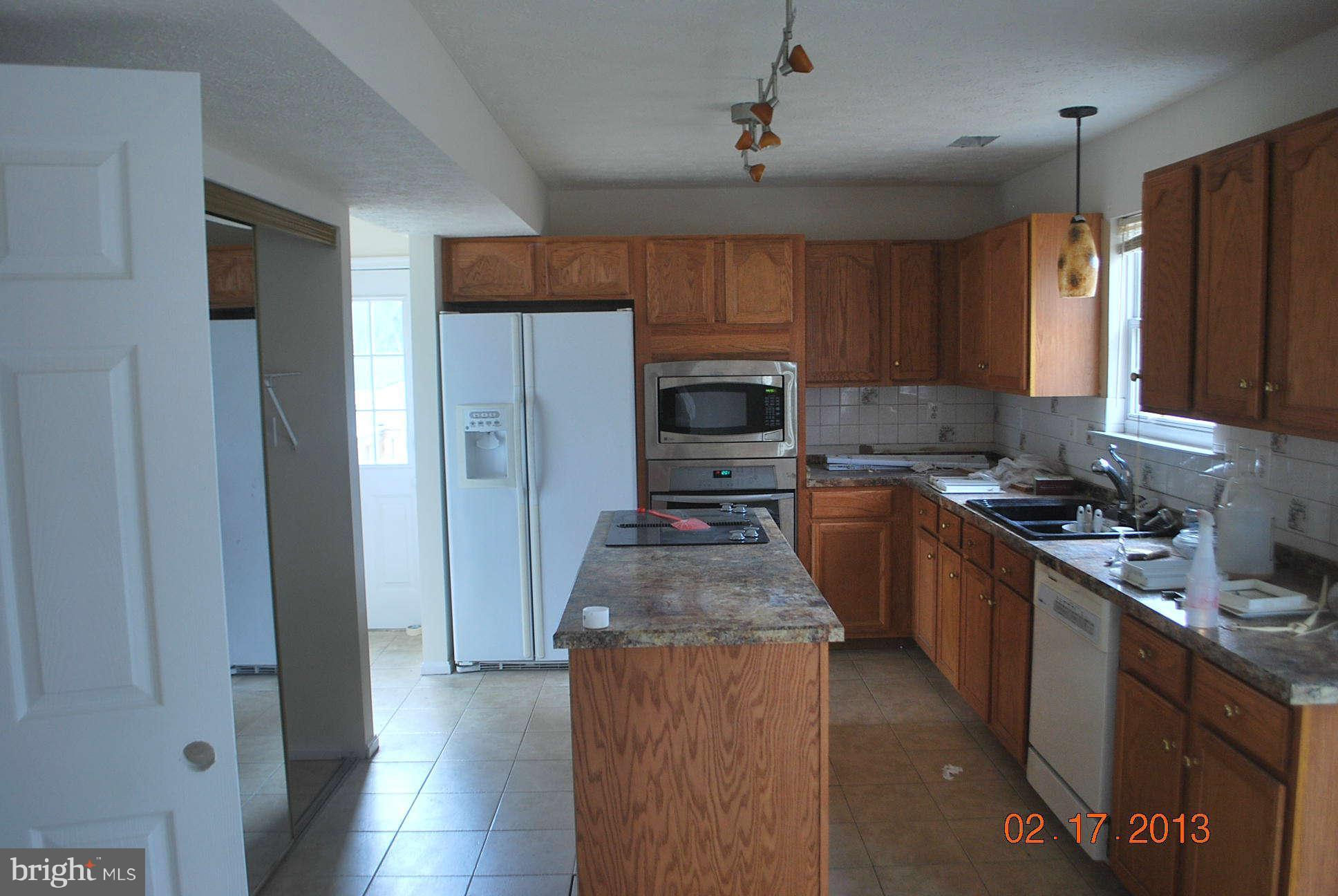 20161 Piney Point Road Callaway, MD 20620 - Photo 2 of 17 a kitchen with stainless steel appliances granite countertop a refrigerator a sink dishwasher a stove with wooden cabinets and floor