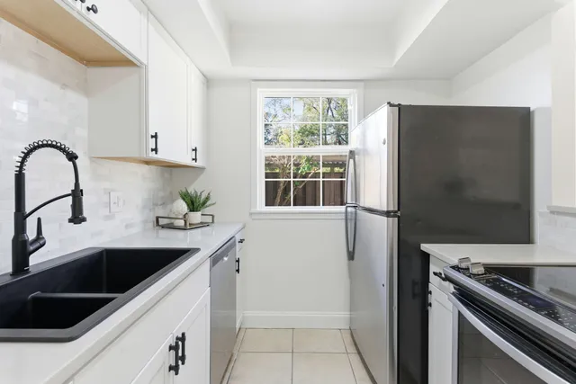 a kitchen with stainless steel appliances a sink a stove and a refrigerator