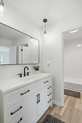 a bathroom with a sink vanity granite and a mirror