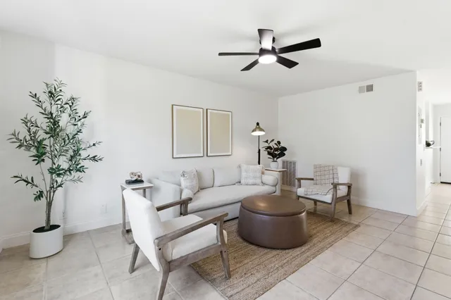 a living room with furniture and a potted plant