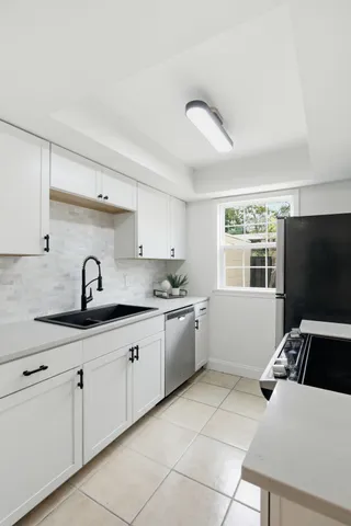a kitchen with granite countertop a sink and a stove top oven